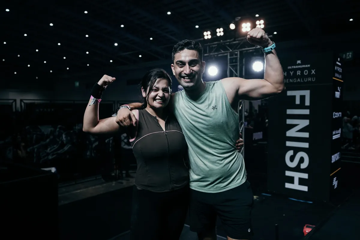 Akshit and his partner flexing at the HYROX Bengaluru finish line